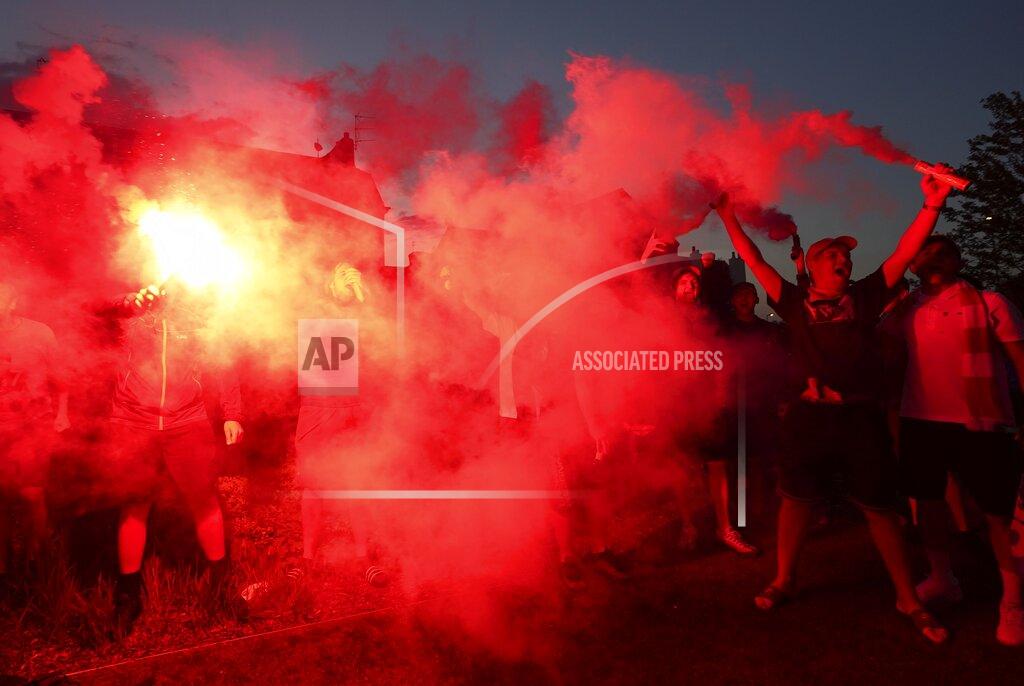 Jon Super Liverpool supporters celebrates outside Anfield Stadium in Liverpool, England, Thursday, June 25, 2020 after hearing Chelsea had scored in the English Premier League soccer match between Chelsea and Manchester City. Liverpool will be crowned Premier League champions if Manchester City fail to beat Chelsea. (AP Photo/Jon Super)