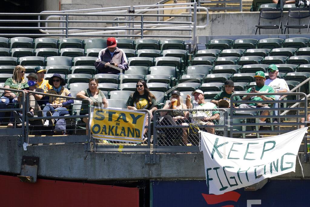 Jeff Chiu Fans sit behind a sign that reads Stay in Oakland during the first inning of a baseball game between the Oakland Athletics and the Los Angeles Angels in Oakland, Calif., Tuesday, July 20, 2021. (AP Photo/Jeff Chiu)