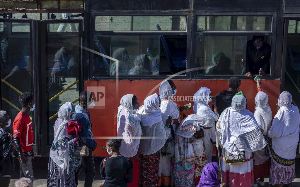 Mulugeta Ayene Passengers queue to get on a bus in the capital Addis Ababa, Ethiopia Friday, Nov. 6, 2020. Ethiopia's prime minister says airstrikes have been carried out against the forces of the country's Tigray region, asserting that the strikes in multiple locations "completely destroyed rockets and other heavy weapons." (AP Photo/Mulugeta Ayene)