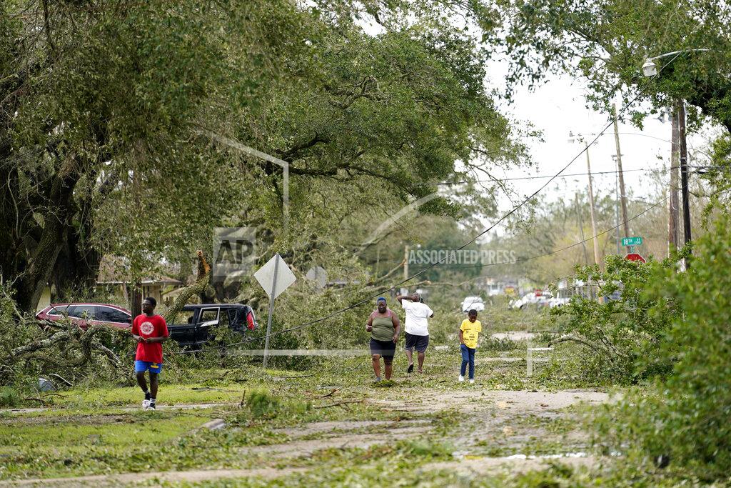Gerald Herbert People survey the damage to their neighborhood on Thursday, Aug. 27, 2020, in Lake Charles, La., in the aftermath of Hurricane Laura. (AP Photo/Gerald Herbert)
