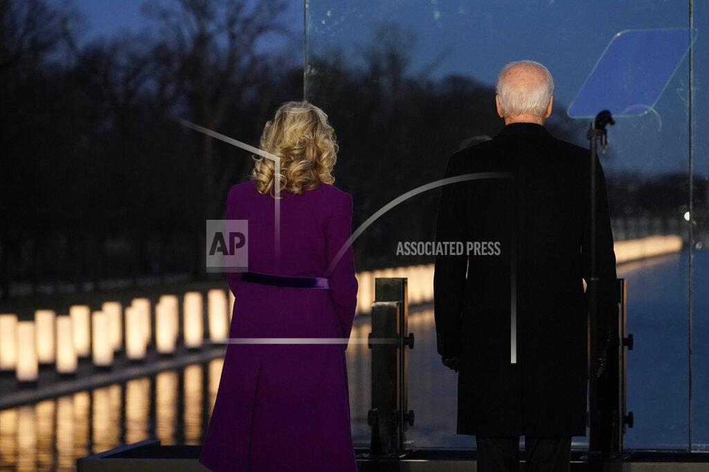 President-elect Joe Biden and his wife Jill Biden look out at lights during a COVID-19 memorial, with lights placed around the Lincoln Memorial Reflecting Pool, Tuesday, Jan. 19, 2021, in Washington. (AP Photo/Alex Brandon)