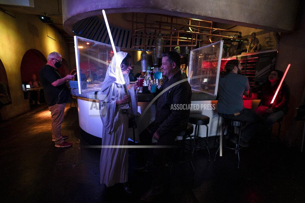 Jae C. Hong Elen Monocroussos, left, and boyfriend, James Stevens, are dressed in Star Wars costumes as they celebrate Star Wars Day at Scum and Villainy Cantina, a geek bar located on Hollywood Blvd, in Los Angeles, Tuesday, May 4, 2021. California has the lowest infection rate in the country. Los Angeles County, which is home to a quarter of the state's nearly 40 million people and has endured a disproportionate number of the state's 60,000 deaths, didn't record a single COVID-19 death Sunday or Monday, which was likely due to incomplete weekend reporting but still noteworthy. (AP Photo/Jae C. Hong)