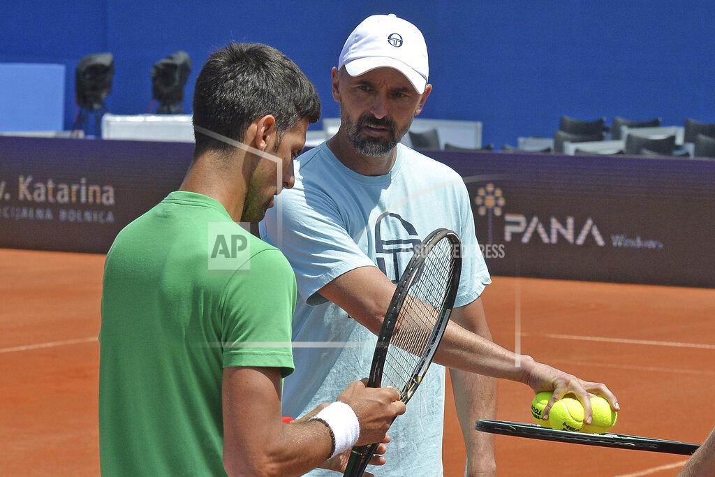 Zvonko Kucelin In this photo taken June 18, 2020, former Wimbledon champion Goran Ivanisevic, left, who now coaches top-ranked Novak Djokovic, right, attends a training session during an exhibition tournament in Zadar, Croatia. The Croatian great, who won his only Grand Slam title at the All England Club in 2001, wrote on Instagram that he tested positive for coronavirus after two negative tests in the last 10 days. (AP Photo/Zvonko Kucelin)