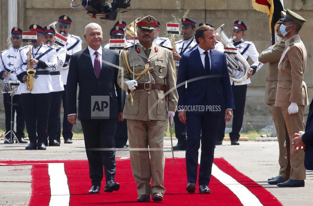 Gonzalo Fuentes Iraqi President Barham Salih and French President Emmanuel Macron, right, review the troops as he arrives at the Salam Palace Wednesday, Sept. 2, 2020 in Baghdad. Macron is the first head of state to visit the Iraqi capital since Prime Minister Mustafa al-Kadhimi, Iraq's former intelligence chief, formed a new government in May. (Gonzalo Fuentes/Pool via AP)
