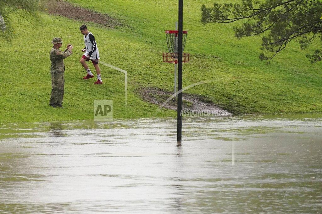 Ross D. Franklin People check out the flooding at Vista del Camino Park as heavy rains come down, Friday, July 23, 2021, in Scottsdale, Ariz. (AP Photo/Ross D. Franklin)