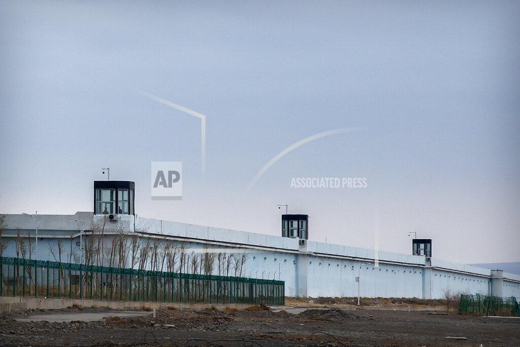 Mark Schiefelbein FILE - People stand in a guard tower on the perimeter wall of the Urumqi No. 3 Detention Center in Dabancheng in western China's Xinjiang Uyghur Autonomous Region on April 23, 2021. State officials took AP journalists on a tour of a "training center" turned detention site in Dabancheng sprawling over 220 acres and estimated to hold at least 10,000 prisoners - making it by far the largest detention center in China and among the largest on the planet. (AP Photo/Mark Schiefelbein, File)