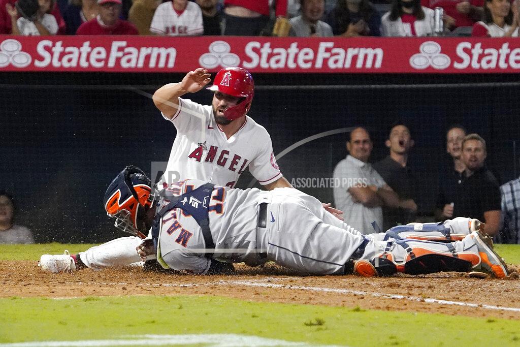 Mark J. Terrill Los Angeles Angels' Jack Mayfield, top, is tagged out at home by Houston Astros catcher Martin Maldonado while trying to score after Jose Rojas was safe at first on a fielding error by second baseman Jose Altuve during the sixth inning of a baseball game Thursday, Sept. 23, 2021, in Anaheim, Calif. (AP Photo/Mark J. Terrill)