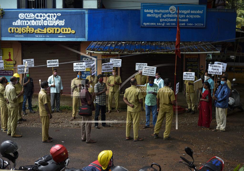R S Iyer Electricity board workers hold placards in solidarity with Friday's nationwide trade union protest before starting the day's work in Kochi, Kerala state, India, Friday, May 22, 2020. India's central bank on Friday cut its key interest rate to 4% to revive the economy severely hit the coronavirus outbreak and a two-month lockdown. (AP Photo/R S Iyer)
