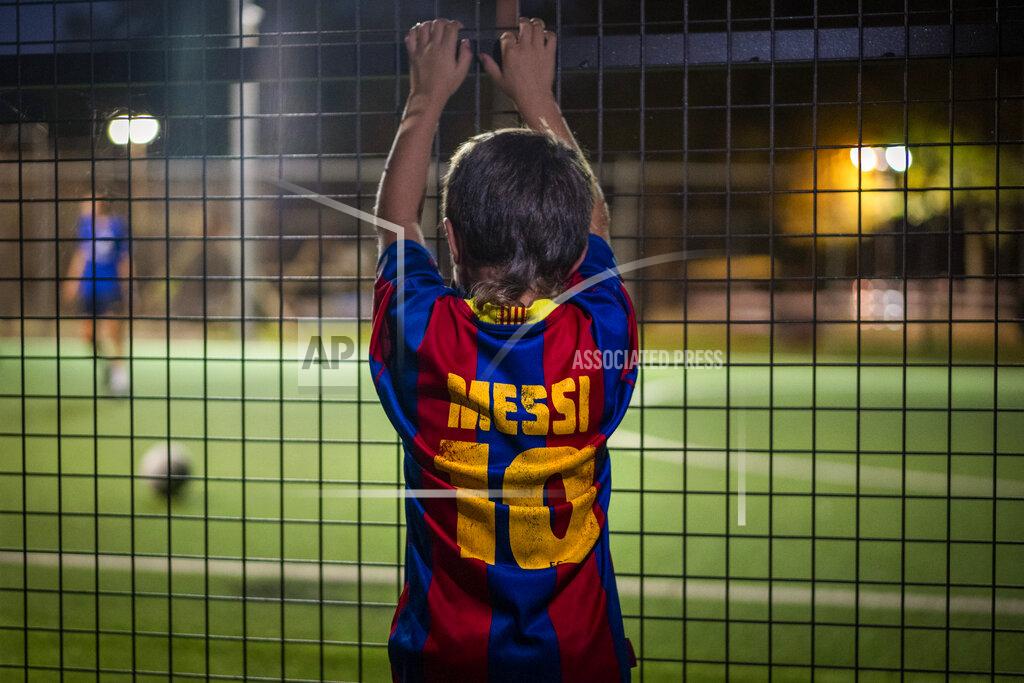 Emilio Morenatti A boy wearing a shirt with the name of Barcelona soccer player Lionel Messi looks at at a soccer match in Banyoles, in Girona province, Spain on Wednesday, Sept. 2, 2020. Lionel Messi's future at Barcelona looked no closer to being resolved after the first meeting between the player's father and club officials on Wednesday ended without an agreement, a person with knowledge of the situation told The Associated Press. (AP Photo/Emilio Morenatti)