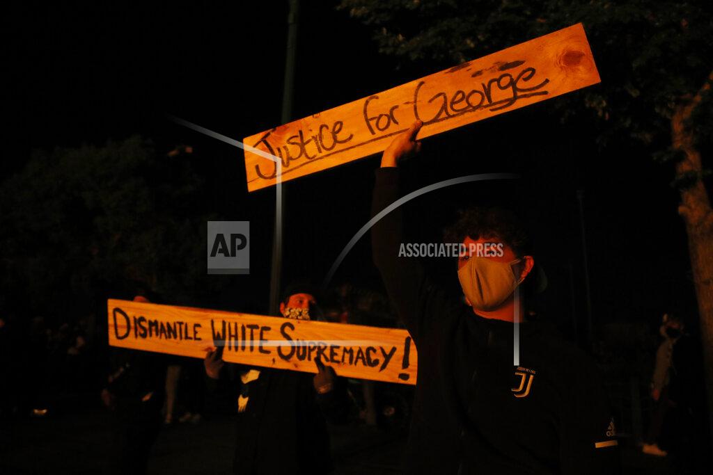 Julio Cortez Protesters gather outside the burning Minneapolis police 3rd Precinct building Thursday, May 28, 2020, in Minneapolis. Protests over the death of George Floyd, a black man who died in police custody Monday, broke out in Minneapolis for a third straight night. (AP Photo/Julio Cortez)