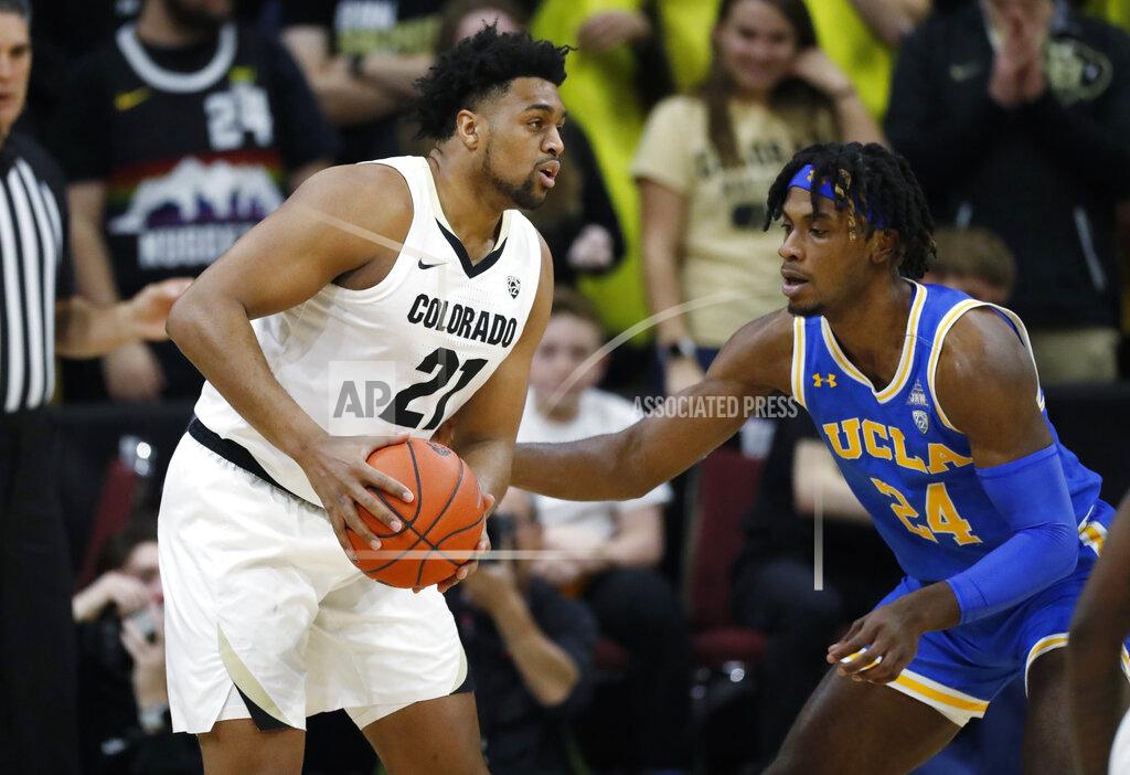 David Zalubowski Colorado forward Evan Battey, left, looks to pass the ball as UCLA forward Jalen Hill defends in the first half of an NCAA college basketball game Saturday, Feb. 22, 2020, in Boulder, Colo. (AP Photo/David Zalubowski)