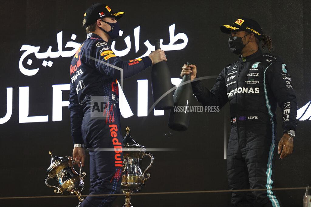 Lars Baron Mercedes driver Lewis Hamilton of Britain, winner, right, celebrates with Red Bull driver Max Verstappen of the Netherlands on the podium after the Bahrain Formula One Grand Prix at the Bahrain International Circuit in Sakhir, Bahrain, Sunday, March 28, 2021. (Lars Baron, Pool via AP)