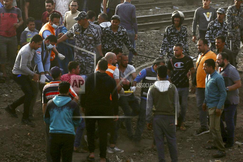 Fadel Dawood Medics carry an injured man at the site where a passenger train derailed injuring at least 100 people, in Banha, Qalyubia province, Egypt, Sunday, April 18, 2021. At least eight train wagons ran off the railway, the provincial governor's office said in a statement. (AP Photo/Fadel Dawood)