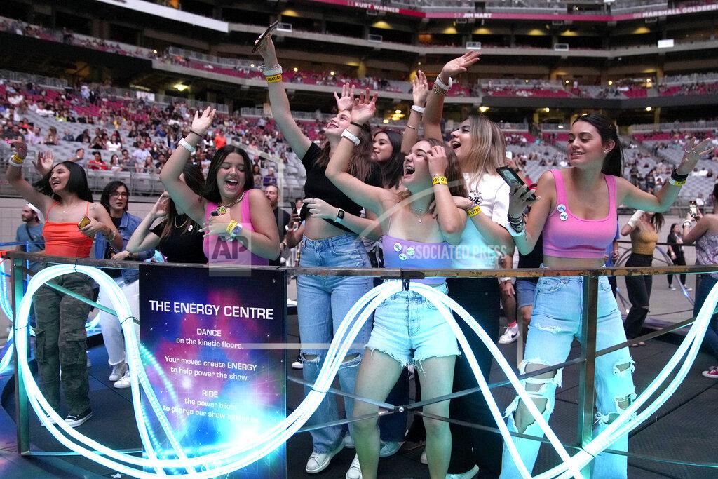 Rick Scuteri Concertgoers dance during Coldplay's Music of the Spheres world tour on Thursday, May 12, 2022, at State Farm Stadium in Glendale, Ariz. The band has included energy-storing stationary bikes to their latest world tour, encouraging fans to help power the show as part of a push to make the tour more environmentally friendly. (Photo by Rick Scuteri/Invision/AP)