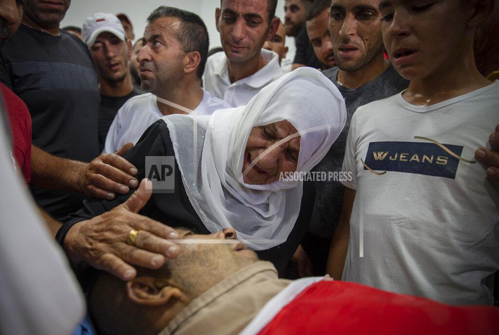 Majdi Mohammed A Palestinian woman mourns while taking a farewell look at the body of Raed Jadallah, 39, who was killed by Israeli forces at the western entrance of his village while returning from work in the early hours of Wednesday morning, during his funeral, in the West Bank village of Beit Ur al-Tahta, Wednesday, Sep. 1, 2021. (AP Photo/Majdi Mohammed)