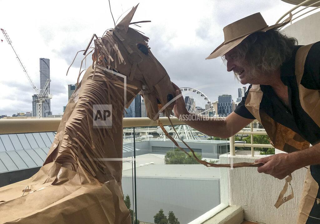 David Marriott CORRECTS NAME - David Marriott poses with his paper horse Russel in his hotel room in Brisbane, Australia, April 3, 2021. While in quarantine inside his Brisbane hotel room, the art director was bored and started making a cowboy outfit from the paper bags his meals were being delivered in. His project expanded to include a horse and a clingfilm villain that he has daily adventures with, in images that have gained a huge online following. (David Marriott via AP)