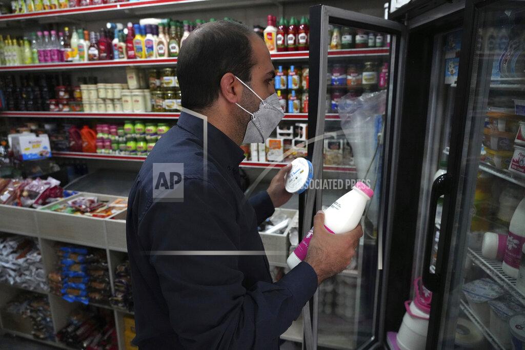 Vahid Salemi A man shops at a grocery store in Tehran, Iran, Wednesday, May 11, 2022. Iran abruptly raised prices as much as 300% for a variety of staples such as cooking oil, chicken, eggs and milk on Thursday. (AP Photo/Vahid Salemi)