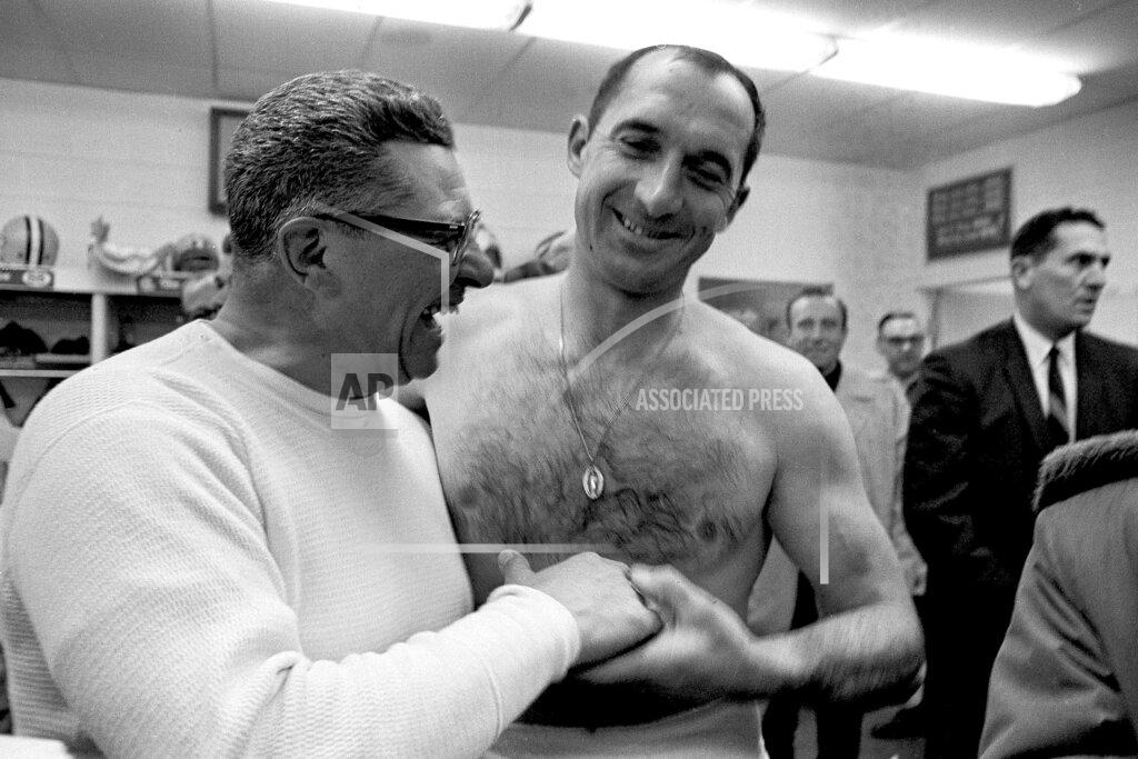 Uncredited FILE - In this Dec. 26, 1965, file photo, Green Bay Packers football coach Vince Lombardi, left, and quarterback Zeke Bratkowski celebrate in the Packers' dressing room in Green Bay, Wis., after Bratkowski took over direction of the Packers when Bart Starr was hurt on the first play of the Western Division NFL playoff game against the Baltimore Colts. The Packers say Bratkowski, the quarterback who backed up Bart Starr during the team’s 1960s dynasty, died Monday, Nov. 11, 2019, at his Florida home at age 88. (AP Photo/File)