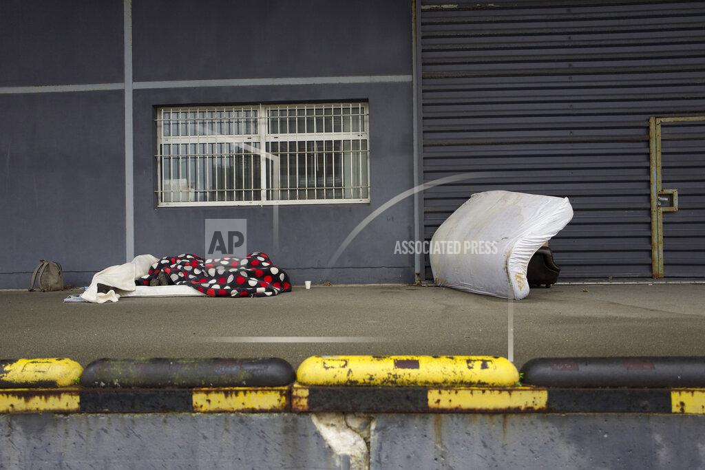 Rafael Yaghobzadeh Migrants sleep on the pavement Thursday, Nov. 25, 2021 in Calais, northern France. Children and pregnant women were among at least 27 migrants who died when their small boat sank in an attempted crossing of the English Channel, a French government official said Thursday. French Interior Minister Gerald Darmanin also announced the arrest of a fifth suspected smuggler thought to have been involved in what was the deadliest migration tragedy to date on the dangerous sea lane.(AP Photo/Rafael Yaghobzadeh)