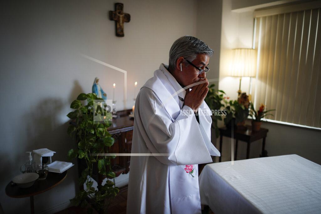 John Minchillo Fabian Arias, a Lutheran pastor with Saint Peter's Church in Manhattan, prepares to give Sunday services at his home via an internet livestream broadcast, Sunday, May 10, 2020, in the Bronx borough of New York. (AP Photo/John Minchillo)