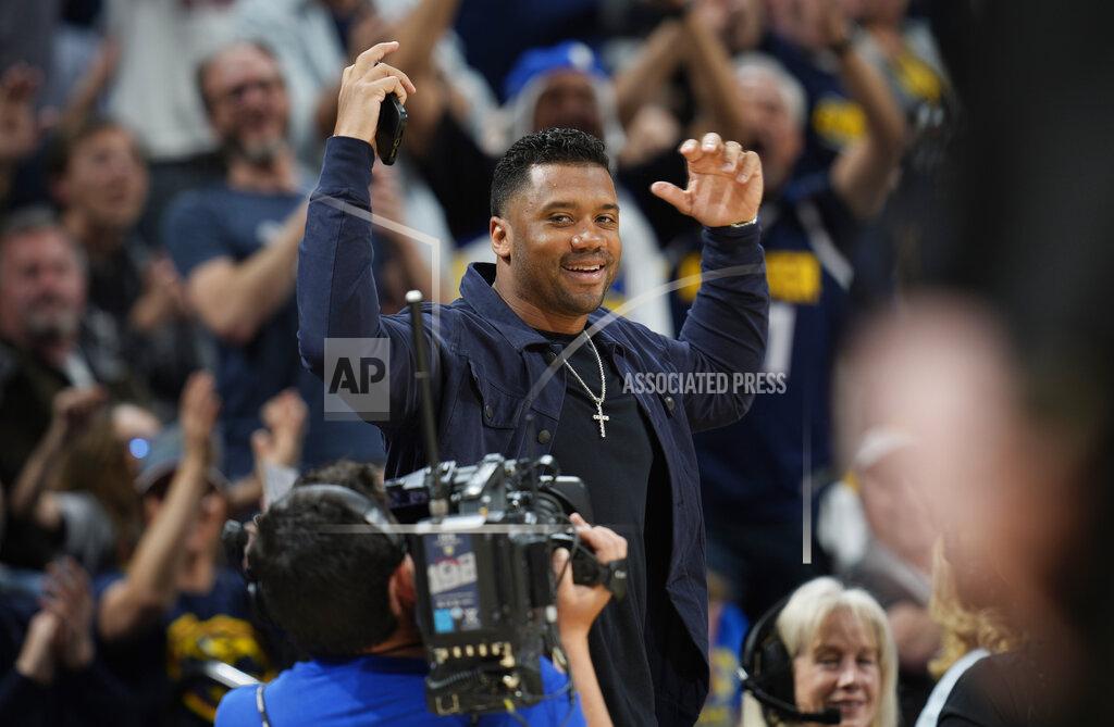 David Zalubowski Denver Broncos quarterback Russell Wilson gestures to the crowd during a timeout in the first half of Game 4 of an NBA basketball first-round Western Conference playoff series between the Denver Nuggets and the Golden State Warriors, Sunday, April 24, 2022, in Denver. (AP Photo/David Zalubowski)