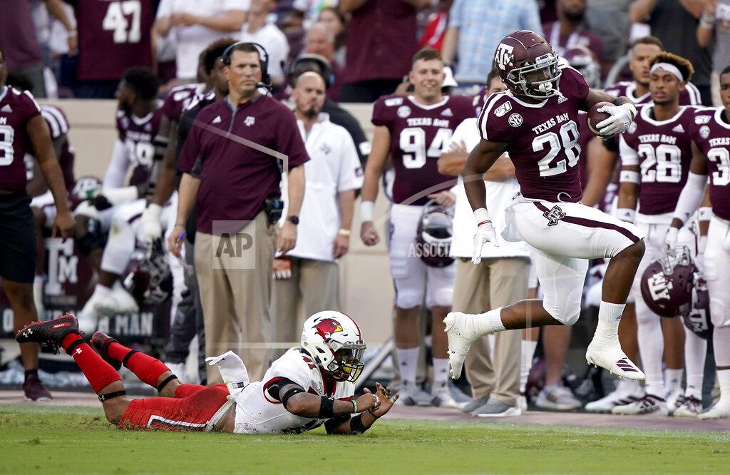 Sam Craft Texas A&M running back Isaiah Spiller (28) is tripped up by Lamar defensive back Michael Lawson (41) after a first down run during the first half of an NCAA college football game, Saturday, Sept. 14, 2019, in College Station, Texas. (AP Photo/Sam Craft)