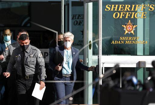 Santa Fe County Sheriff Adan Mendoza, left, and Santa Fe District Attorney Mary Carmack-Altwies exit the sheriff's office to address the media at a news conference in Santa Fe, N.M. Wednesday, Oct. 27, 2021. New Mexico authorities said Wednesday they have recovered a lead projectile believed to have been fired from the gun used in the fatal movie-set shooting. (AP Photo/Andres Leighton)