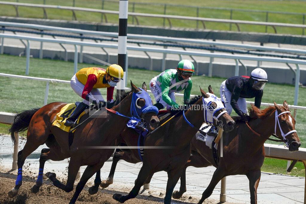 Ashley Landis In this Friday, May 22, 2020 photo, jockeys wearing face masks ride in the first horse race at Santa Anita Park in Arcadia, Calif. Horse racing returned to the track after being idled for one and a half months because of public health officials' concerns about the coronavirus pandemic. (AP Photo/Ashley Landis)