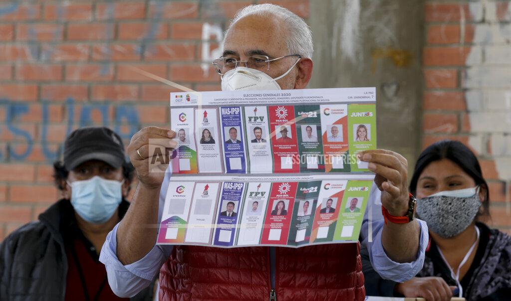 Martin Mejia Carlos Mesa, who is running for president with the Citizen Community party, shows the ballot during general elections in La Paz, Bolivia, Sunday, Oct. 18, 2020. (AP Photo/Martin Mejia)