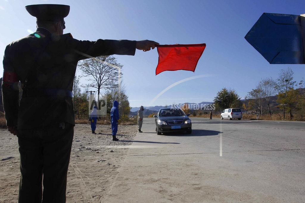 Jon Chol Jin FILE - In this Oct. 28, 2020, file photo, hygienic and anti-epidemic officials work to disinfect the vehicles and check the temperature of the people coming to the city of Wonsan, Kangwon Province, North Korea. With a population of more than 25 million, North Korea remains by far the largest nation yet to report a single case, although there's widespread skepticism over leader Kim Jong Un's claim of a perfect record in keeping out the "evil" virus. (AP Photo/Jon Chol Jin, File)