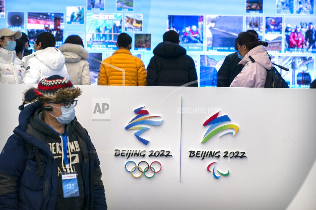 Mark Schiefelbein A journalist wearing a face mask to protect against the spread of the coronavirus looks at an exhibit at a visitors center at the Winter Olympic venues in Yanqing on the outskirts of Beijing, Friday, Feb. 5, 2021. Beijing Olympic organizers showed off the downhill skiing venue and the world's longest bobsled and luge track Friday, one year ahead of the scheduled opening of the 2022 Olympic Winter Games. (AP Photo/Mark Schiefelbein)