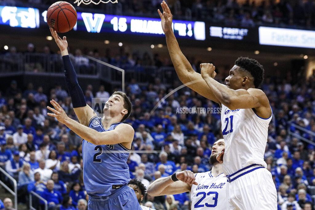 John Minchillo Villanova's Collin Gillespie (2) shoots against Seton Hall's Ike Obiagu (21) and Sandro Mamukelashvili (23) during the first half of an NCAA college basketball game, Wednesday, March 4, 2020, in Newark, N.J. (AP Photo/John Minchillo)
