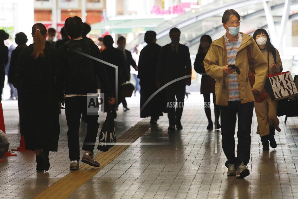 People wearing face masks to help curb the spread of the coronavirus walk underpass in Tokyo, Wednesday, Nov. 18, 2020. (AP Photo/Koji Sasahara)
