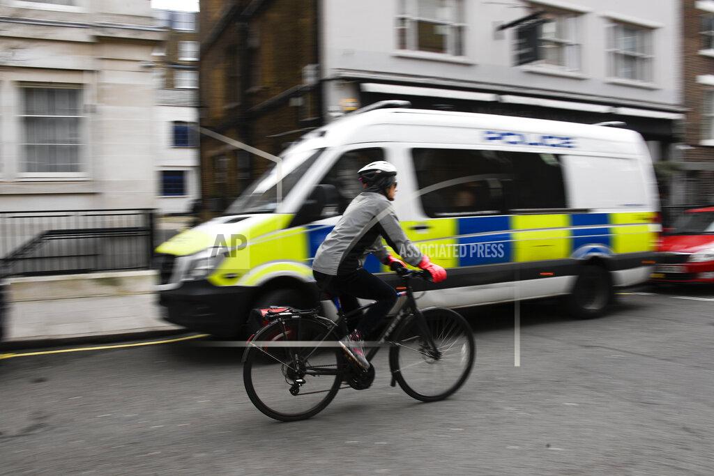 Alberto Pezzali A woman cycles past a Police van parked outside the King Edward VII hospital where Britain's Prince Philip is receiving treatment in London in London, Monday, March 15, 2021. The 99-year-old husband of Queen Elizabeth II remains hospitalized after a heart procedure. (AP Photo/Alberto Pezzali)