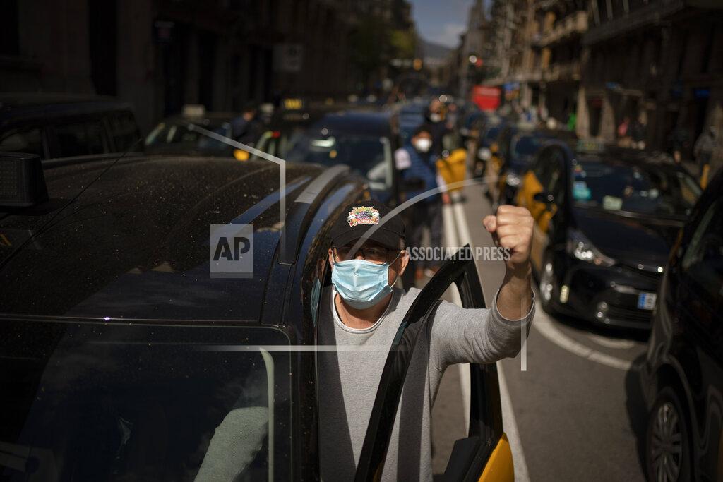Emilio Morenatti Taxi cabs move slowly blocking the traffic along one of the avenues in Barcelona downtown, Spain, Thursday, March 18, 2021. Hundreds of yellow-and-black cabs disrupted Barcelona's road traffic on Thursday to protest against the return of the ride-hailing giant Uber to the northeastern city after a 2-year hiatus. (AP Photo/Emilio Morenatti)