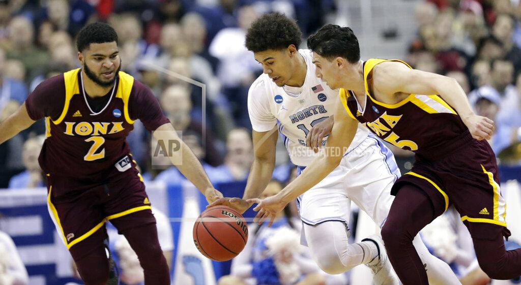 Tony Dejak From left to right, Iona's E.J. Crawford, North Carolina's Cameron Johnson and Iona's Ben Perez battle for the ball in the first half during a first round men's college basketball game in the NCAA Tournament in Columbus, Ohio, Friday, March 22, 2019. (AP Photo/Tony Dejak)