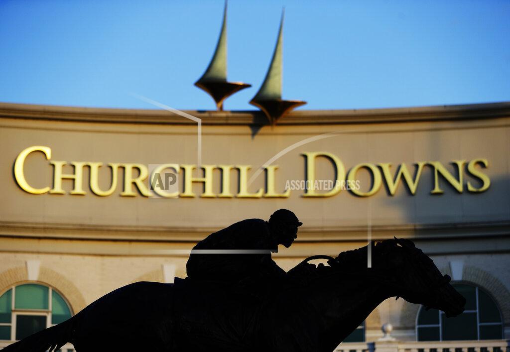 FILE - In this May 6, 2020 file photo a statue of Barbaro is silhouetted at the entrance of Churchill Downs in Louisville, Ky. The Trump administration’s immigration squeeze and the hardships caused by the coronavirus pandemic threaten to leave the horse racing industry short of workers, racing officials warn as they prepare for a reconfigured Kentucky Derby. (AP Photo/Darron Cummings, file)