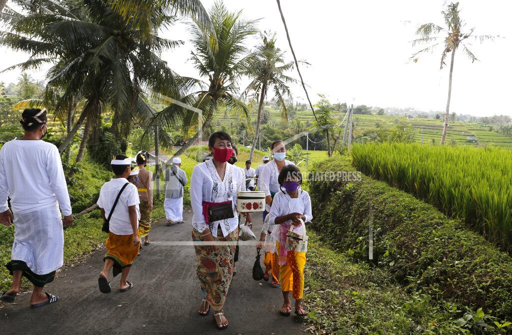 Firdia Lisnawati People wearing face masks as a precaution against coronavirus outbreak walk to a temple at a village in Bali, Indonesia Monday, Sept. 21, 2020. (AP Photo/Firdia Lisnawati)