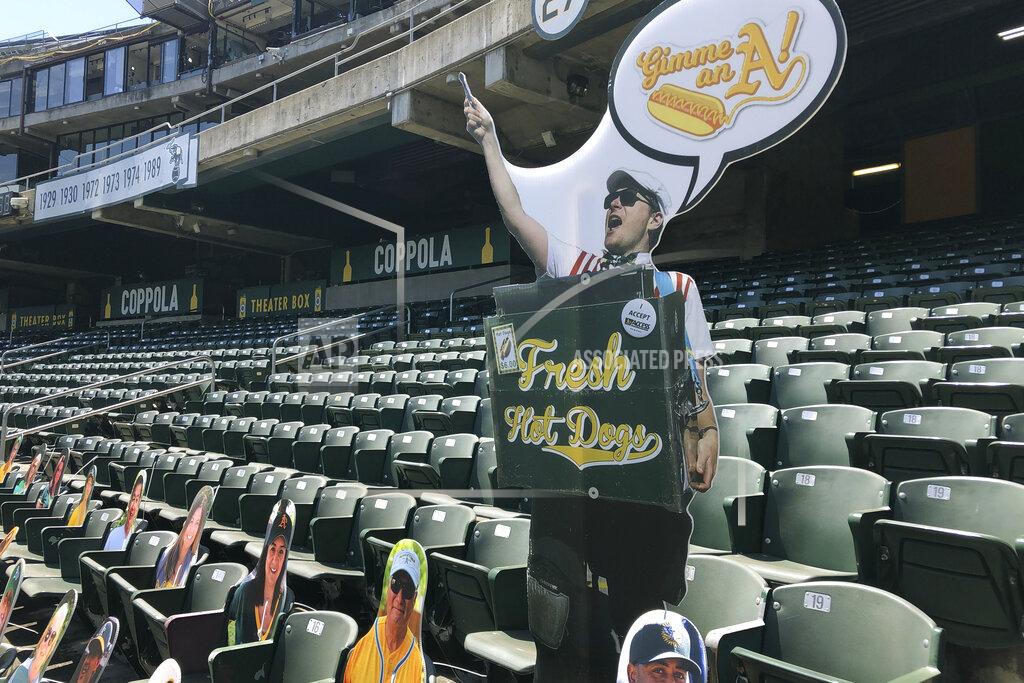 Ben Margot A cardboard hot dog vendors is displayed in the empty stands of the Oakland Coliseum during a baseball game between the Los Angeles Angels and the Oakland Athletics, Monday, July 27, 2020, in Oakland, Calif. (AP Photo/Ben Margot)