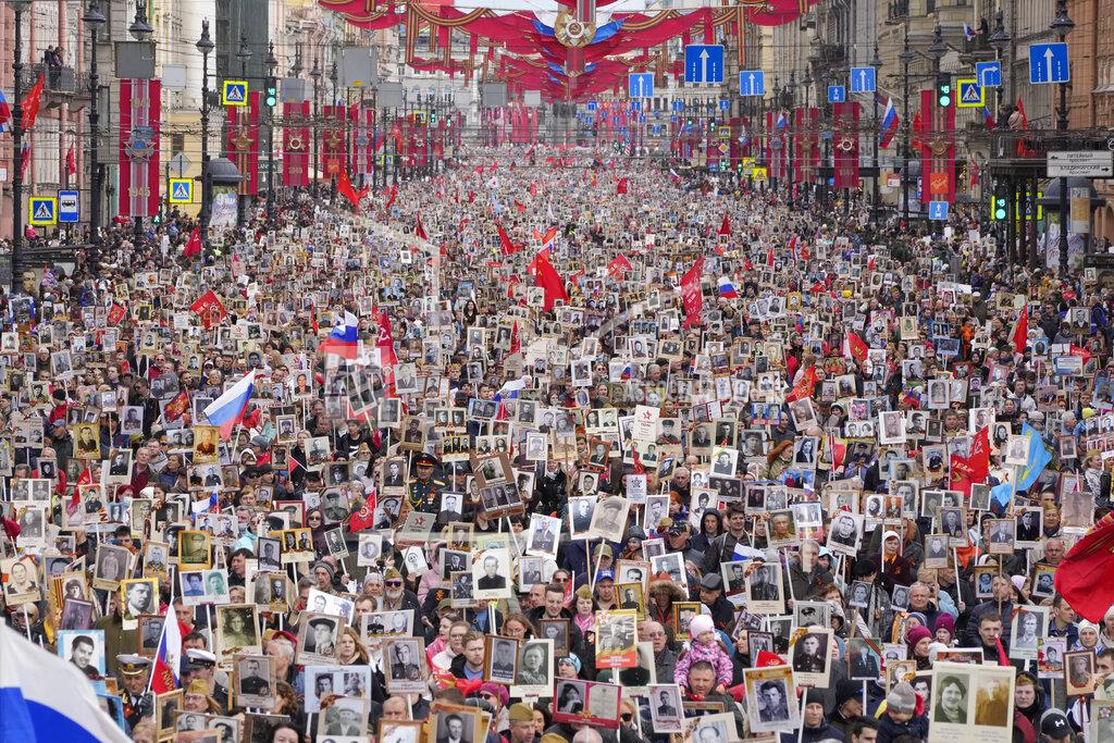 Dmitri Lovetsky People carry portraits of relatives who fought in World War II, during the Immortal Regiment march at the Nevsky prospect, the central avenue of St. Petersburg, Russia, Monday, May 9, 2022, on the occasion of the 77th anniversary of the end of World War II. (AP Photo/Dmitri Lovetsky)