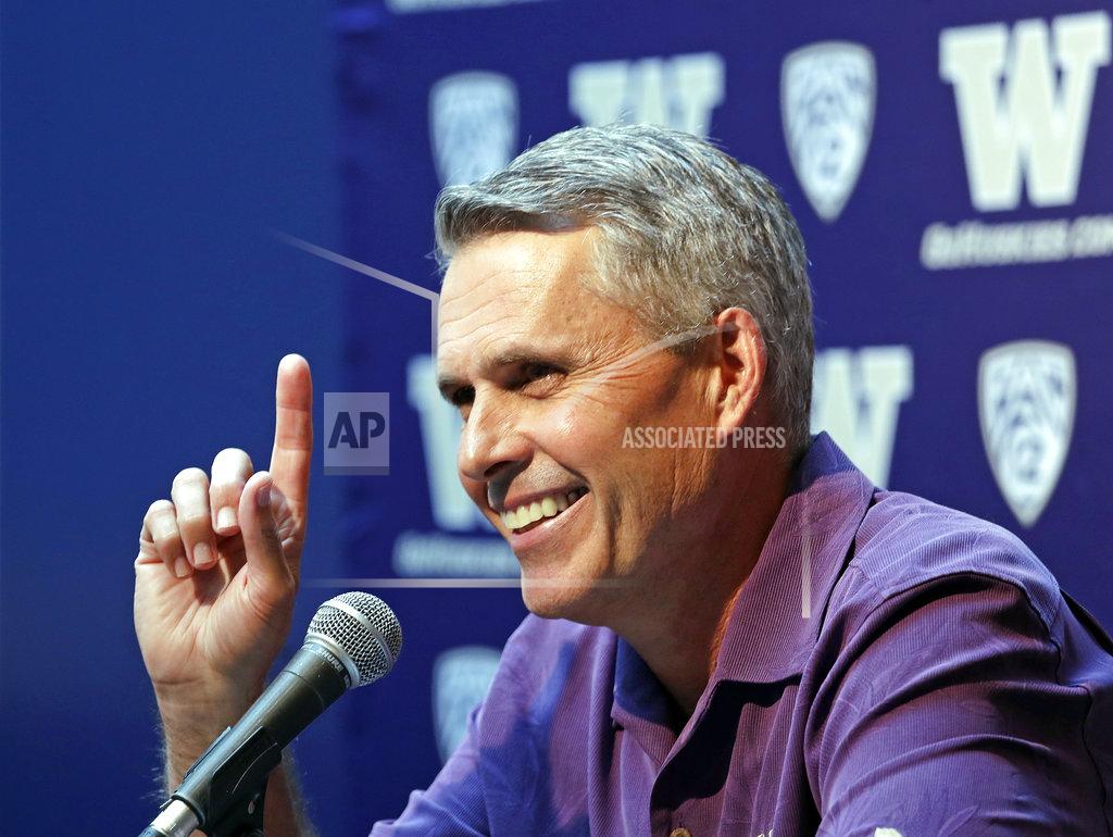 Washington NCAA college head football coach Chris Petersen points skyward in response to hearing Blue Angels jets soar nearby as he speaks at a news conference Thursday, Aug. 2, 2018, in Seattle. Petersen hates expectations, so he's likely loathing Washington being the overwhelming favorite in the Pac-12 and likely top 10 when the preseason AP poll comes out. The Huskies open fall camp on Friday in preparation for the Sept. 1 opener against Auburn. (AP Photo/Elaine Thompson)