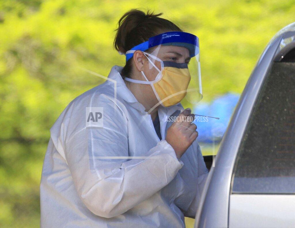 FILE - In this Monday, April 20, 2020, file photo, nurse Tonya Green talks with a patient at Arkansas Surgical Hospital's drive-thru Covid-19 testing site at the New Life Church in North Little Rock, Ark. Arkansas' governor says the state is ramping up coronavirus testing as he nears a decision on whether to allow some businesses to reopen. Gov. Asa Hutchinson said Thursday, April, 23, 2020, the state is launching a "surge" of testing on Friday and Saturday and encouraging anyone in the state with symptoms to get tested. (Staton Breidenthal/The Arkansas Democrat-Gazette via AP, File)