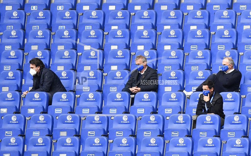 Martin Meissner People with face masks on the tribune during the German Bundesliga soccer match between FC Schalke 04 and FC Augsburg at the Veltins-Arena in Gelsenkirchen, Germany, Sunday, May 24, 2020. The German Bundesliga becomes the world's first major soccer league to resume after a two-month suspension because of the coronavirus pandemic. (AP Photo/Martin Meissner, Pool)