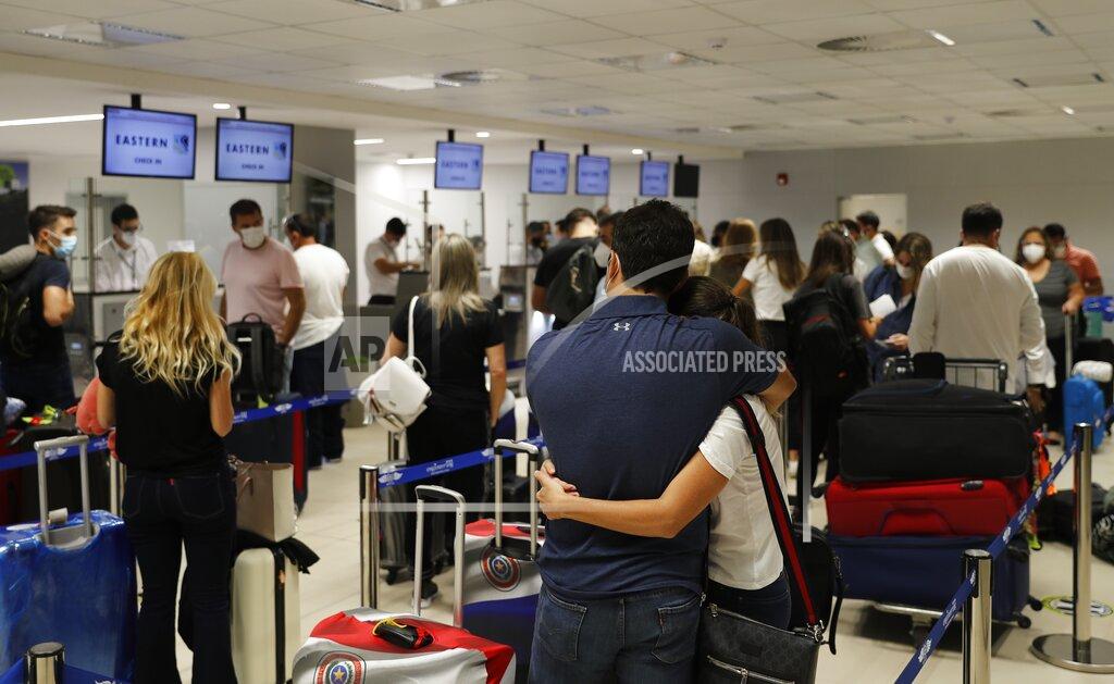 Jorge Saenz People check-in for a flight to Miami at Silvio Pettirossi Airport, in Luque Paraguay, Saturday, April 17, 2021. Some of Paraguayan travelers are going to the United States expecting to get a vaccine against COVID-19. (AP Photo/Jorge Saenz)