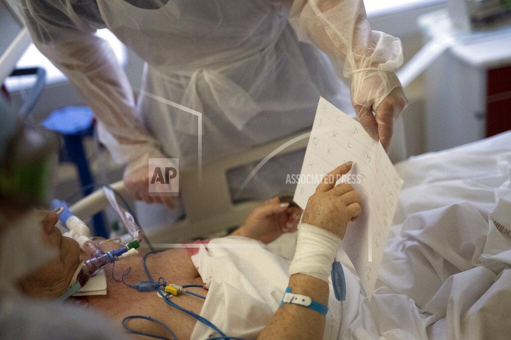 Daniel Cole An intubated patient suffering from COVID-19 communicates with nurses by pointing to an alphabet in the ICU at the La Timone hospital in Marseille, southern France, Tuesday, Feb. 2, 2021. COVID patients occupy 88% of the Marseille region's intensive care beds, and virus pressure on French hospitals is steadily rising in recent weeks despite curfews and other restrictions. (AP Photo/Daniel Cole)