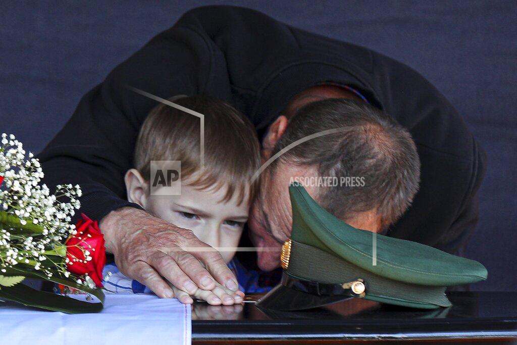Uncredited Father and son of Russian Army Sgt. Daniil Dumenko, 35, who was killed during fighting in Ukraine, mourn during a farewell ceremony in his homeland in Volzhsky, outside Volgograd, Russia, Thursday, May 26, 2022. (AP Photo)