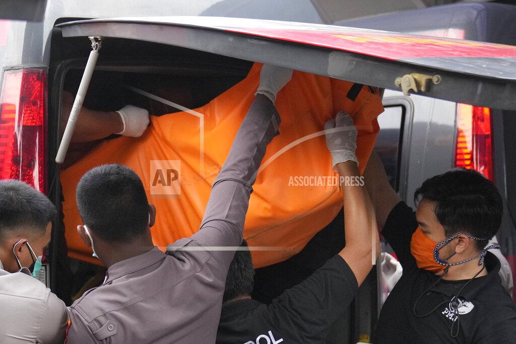 Dita Alangkara Officers load a body bag containing the body of a victim of a prison fire to be transferred to the national police hospital for identification from the local hospital's morgue in Tangerang on the outskirts of Jakarta, Indonesia, Wednesday, Sept. 8, 2021. A massive fire raged through an overcrowded prison near Indonesia's capital early Wednesday, killing a number of inmates. (AP Photo/Dita Alangkara)