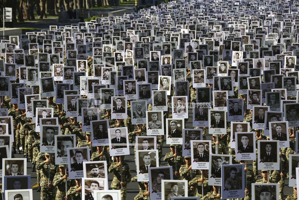 Aziz Karimov Azerbaijan's Army soldiers carry portraits of the soldiers killed during the fighting over Nagorno-Karabakh in 2020 year, during a memorial event in Baku, Azerbaijan, Monday, Sept. 27, 2021. Azerbaijan and Armenia are marking the first anniversary of the start of their six-week war in which more than 6,600 people died and that ended with Azerbaijan regaining control of large swaths of territory. Soldiers carrying photos of comrades killed in the war marched Monday through the center of the Azerbaijaini capital Baku. (AP Photo/Aziz Karimov)