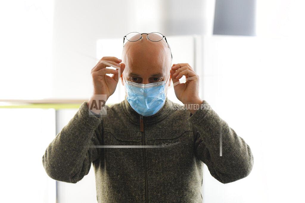 Andreea Alexandru Valeriu Nicolae, a Romanian Roma human rights activist, who runs as an independent in the upcoming parliamentary elections, reaches for his glasses during an interview with the Associated Press, in Bucharest, Romania, Wednesday, Dec. 2, 2020. Romania will hold parliamentary elections on Sunday Dec. 6. (AP Photo/Andreea Alexandru)