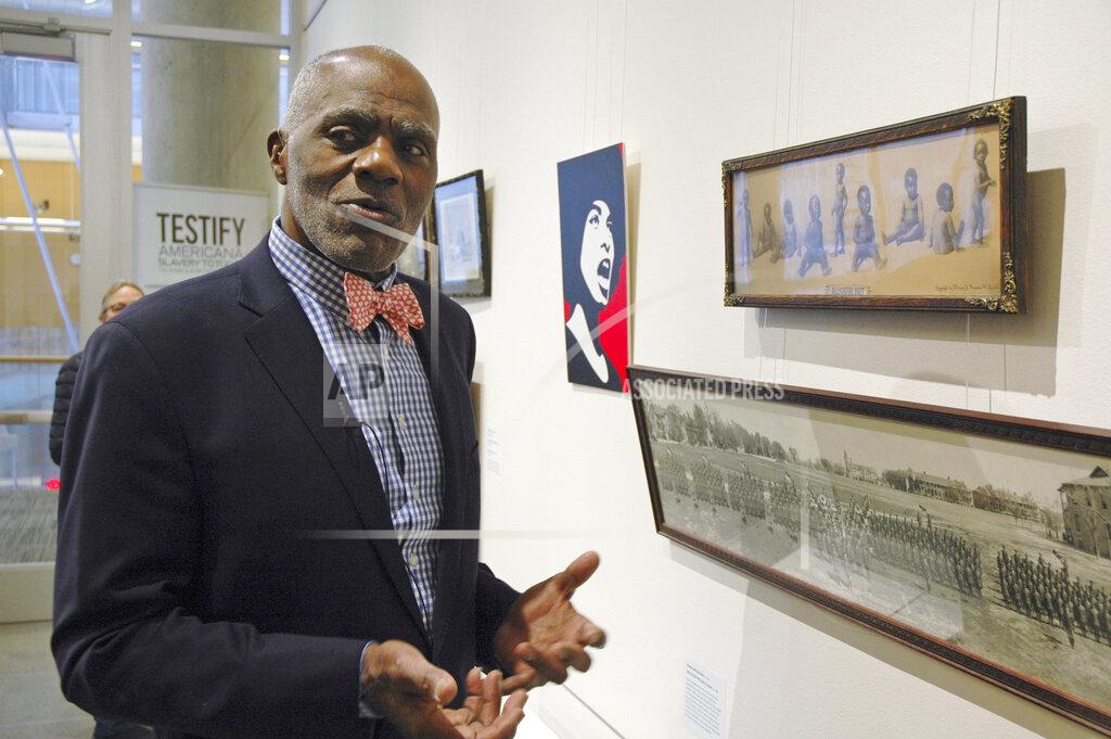 Steve Karnowski FILE - In this Jan. 11, 2018 photo, Alan Page, NFL Hall of Famer and retired Minnesota Supreme Court justice, stands in Minneapolis, by a photo of black babies labeled "Alligator Bait." Page has counted art collection among his many life pursuits, and the former Vikings star has two of his prized pieces up for sale through a New York auction house, each valued at more than $200,000. (AP Photo/Steve Karnowski, File)